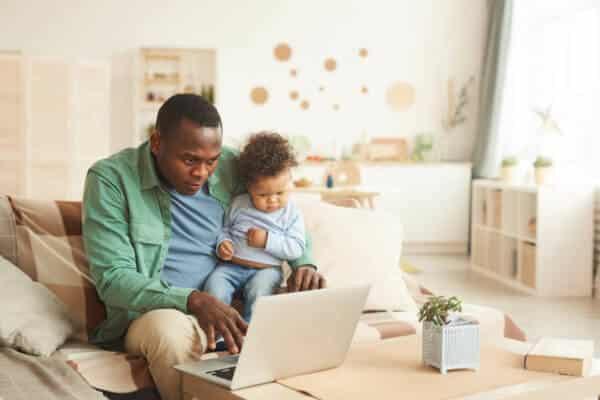 Dad holding small child while receiving telehealth services