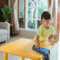 Small child wiping down a yellow activity table