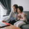 Parent sitting with daughter on a couch accessing Telehealth servicesaccessing