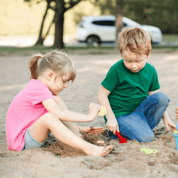 Two small children playing in the sand