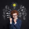 Young boy smiling and dressed in a suit and tie with images of a light bulb over his head surrounded by question marks