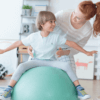 Occupational therapist helping young child balance on a therapy ball